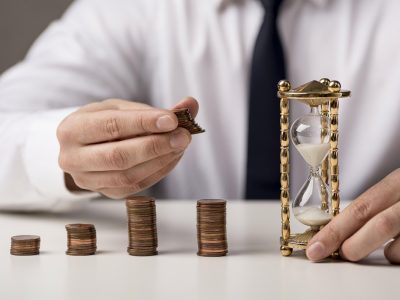 front-view-businessman-with-coins-hourglass kredyt
